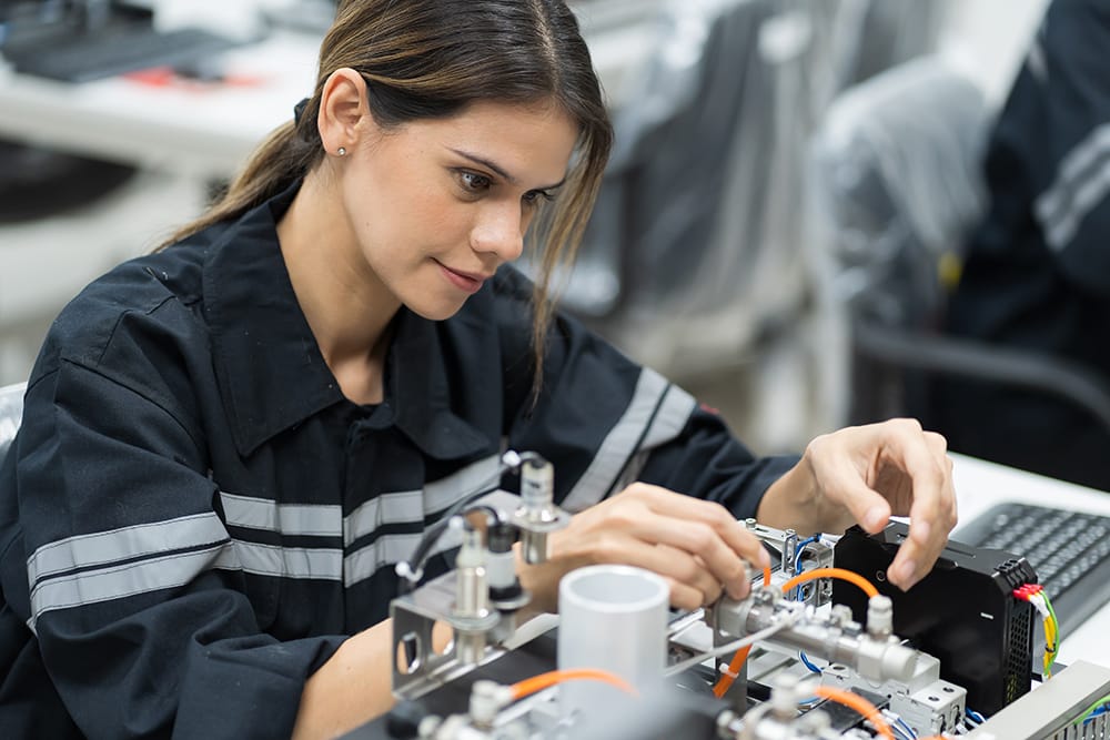 An engineering apprentice assembling components at a workbench